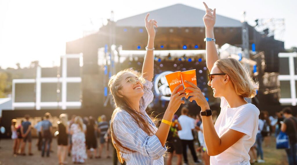 People at an outdoor event with branded plastic cups