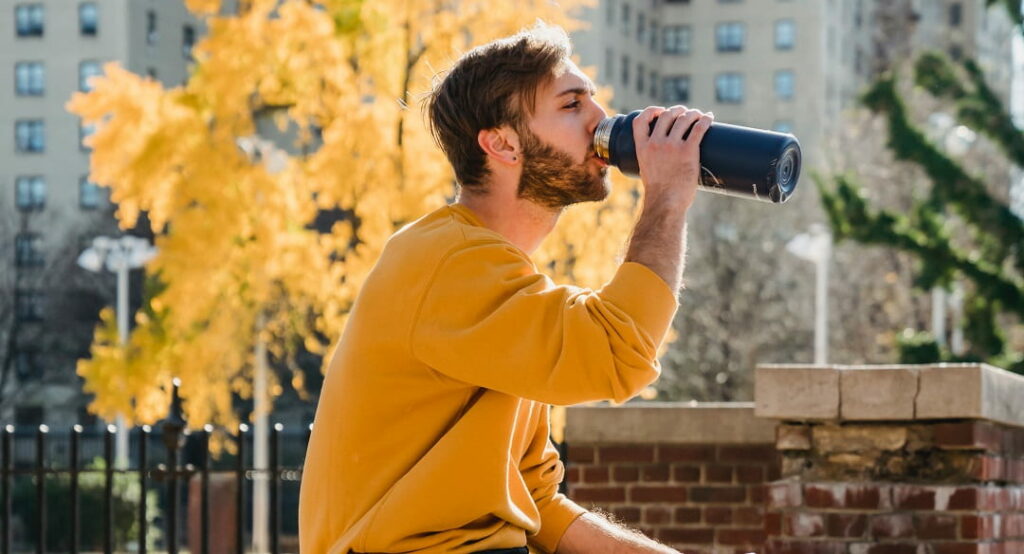 Man drinking from thermal bottle