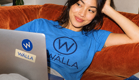 Woman working from home on laptop wearing custom printed blue corporate t-shirt