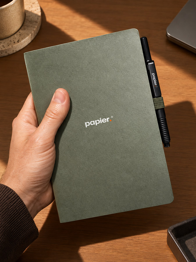 Green branded notebook with a matching logo on the pen