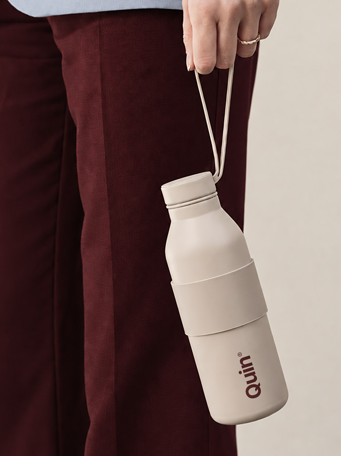 Cream water bottle with a printed logo and carry strap